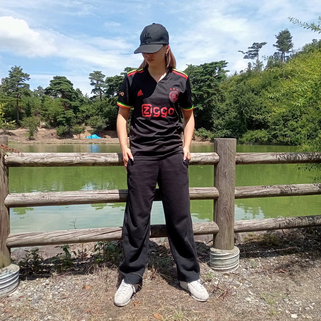 アヤックスの黒いサードユニフォームを私服に合わせた着こなし。胸にZiggoのロゴ