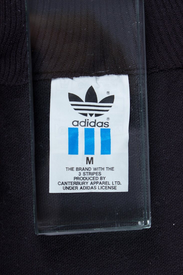 adidasのタグ。トレフォイルと3本線の下に、PRODUCED BY CANTERBURY APPAREL LTD. UNDER ADIDAS LICENSEの表記
