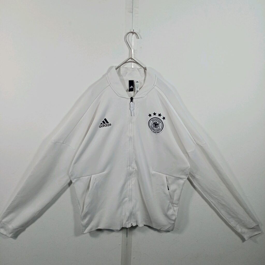 ドイツ代表のadidas製トラックジャケット(白)の正面。胸にadidasのロゴとDFBのエンブレム、4つの星