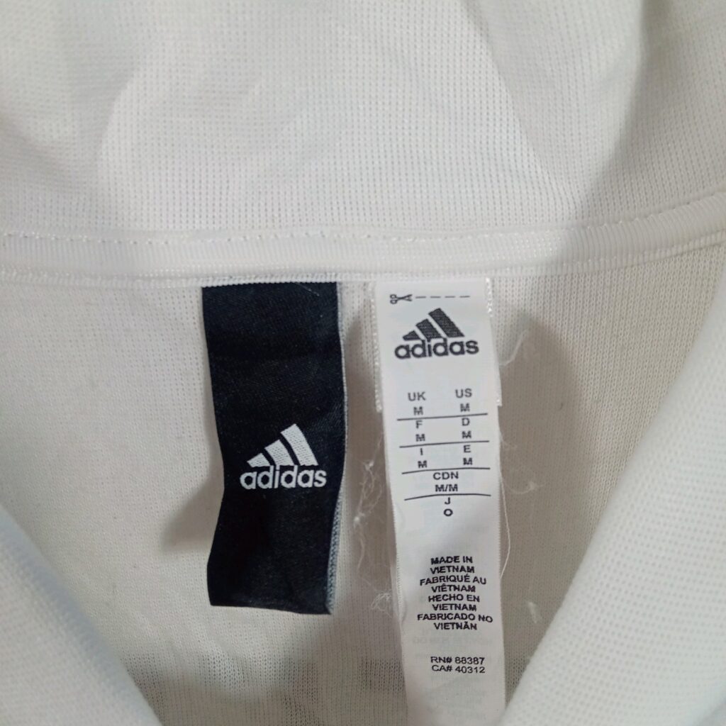 ジャケットの襟裏のadidasのサイズタグ。UK・US表記M、日本表記O、MADE IN VIETNAM